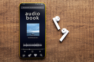 Ljudbok på mobil enhet och trådlösa hörlurar